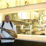 Pastry chef Brett Aubrey walking with pata negra ham