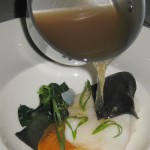 Citrus dashi broth being poured on the cod