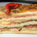 Stromboli bread stuffed with salami, smoked mozzarella, basil and garlic