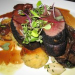 Ash-spiced venison loin with smoked polenta dumplings and dried cherry reduction