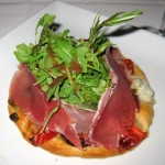 Fig gorgonzola tartlet: warm gorgonzola, prosciutto, fig, walnut arugula, tomato on a fine puff pastry