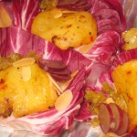 Coquilles St. Jacques dusted in saffron with Champagne grapes, sliced almonds, golden currants, Maui onions and Tarragon vinaigrette in a radicchio leaf