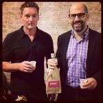 Two tasters hold their brown-bagged wine at Joios' Rooftop Tasting