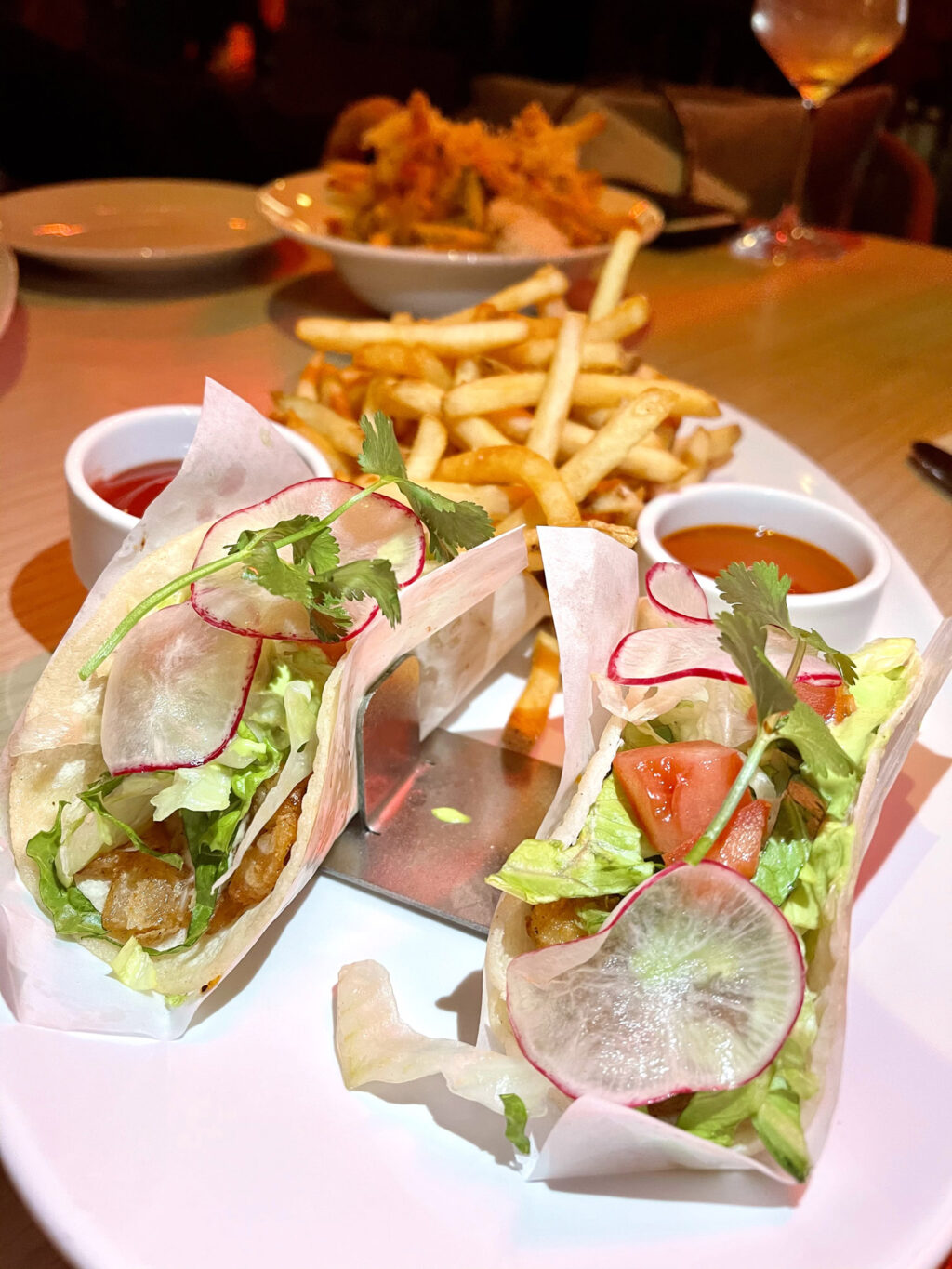 Baja fish tacos, two shrimp + fish tacos, avocado crema, valentina’s, fries